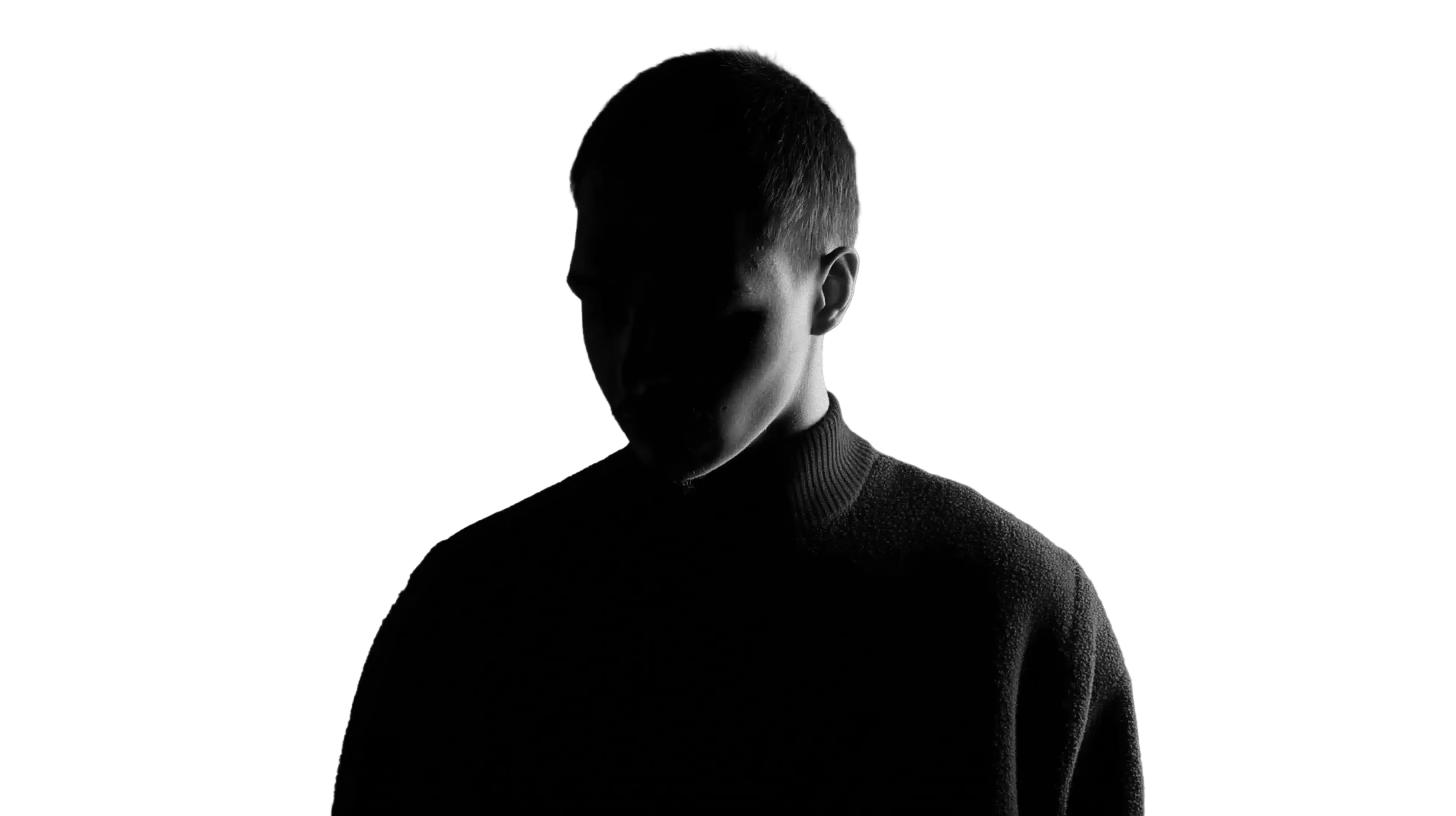 Silhouette of a person with short hair wearing a dark sweater against a black background.