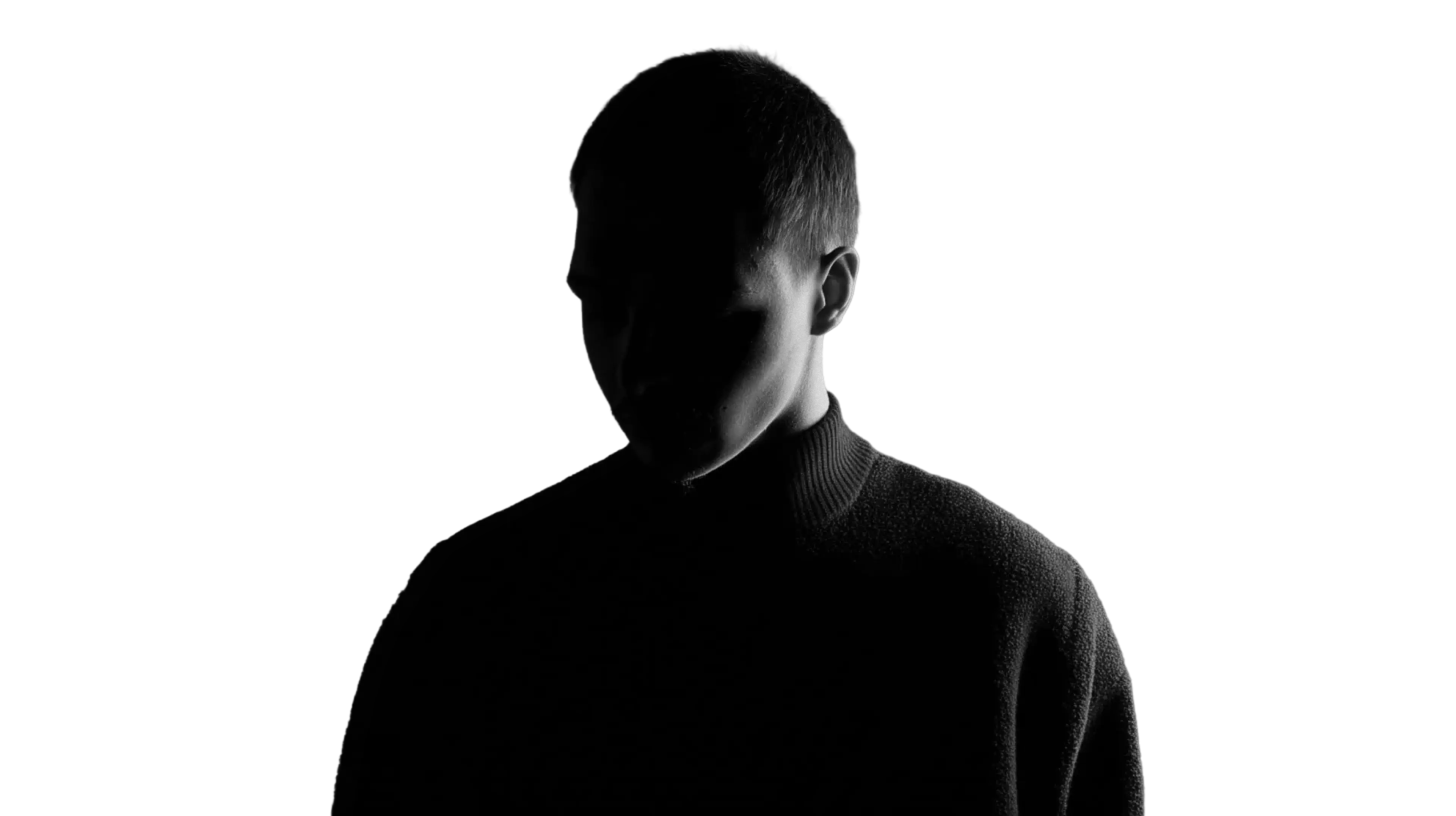 Silhouette of a person with short hair wearing a dark sweater against a black background.